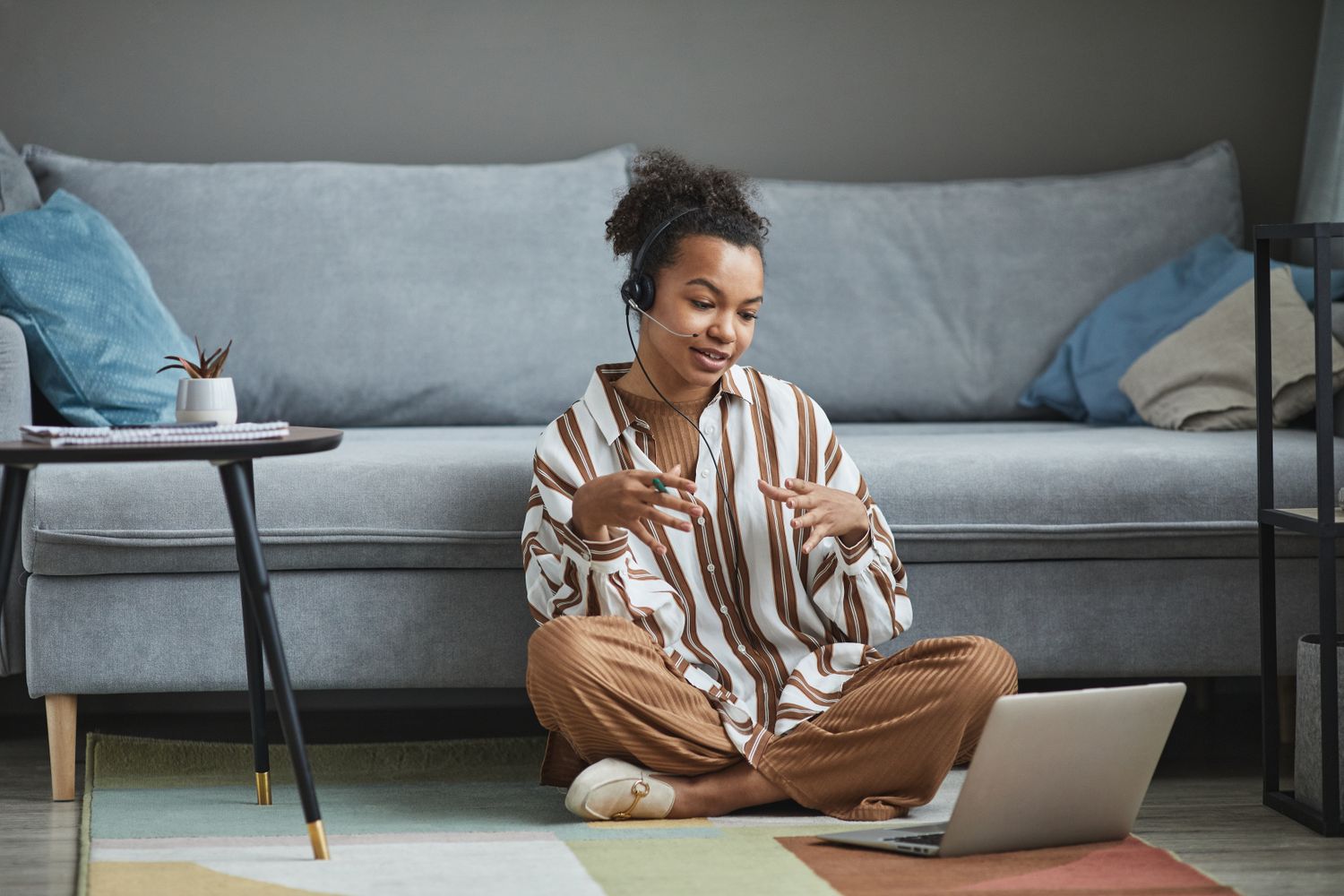A woman connecting by laptop from a comfortable space at home